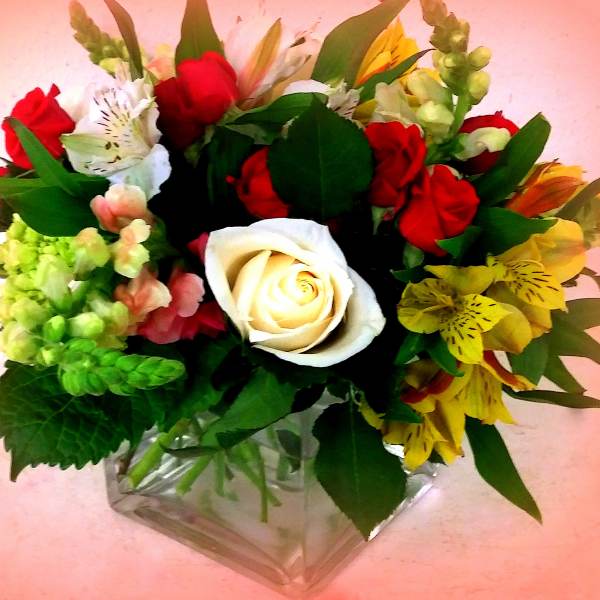 Mixed bouquet with red and white roses in a clear glass vase