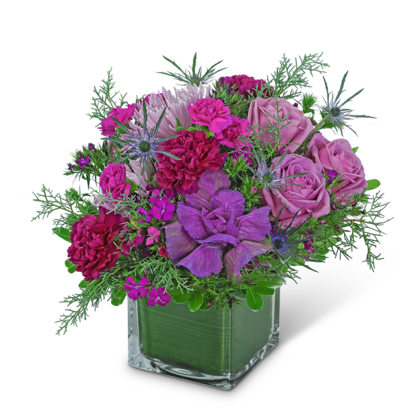 Purple and pink bouquet in a clear square vase