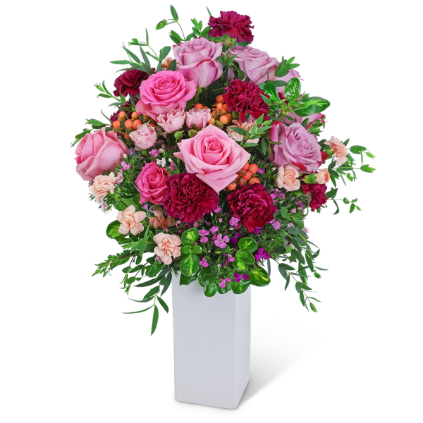Pink and burgundy floral arrangement in a white vase