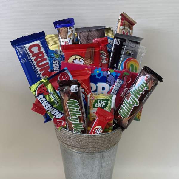 Assorted candy bars arranged in a galvanized metal bucket