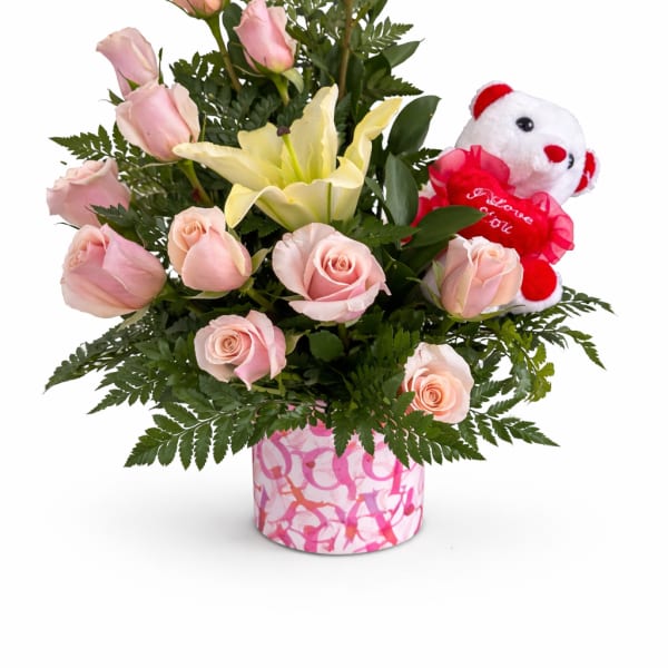 Pink roses and a yellow lily in a pink patterned vase with a teddy bear
