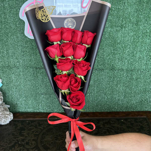 Bouquet of red roses wrapped in black paper with a red ribbon