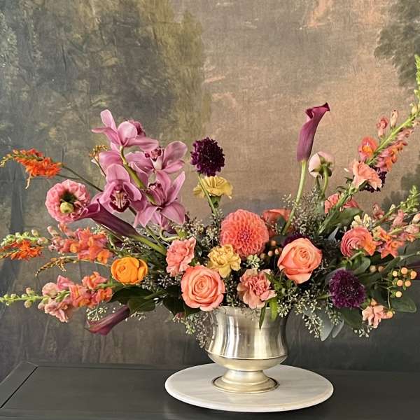 Colorful floral arrangement in a silver pedestal vase