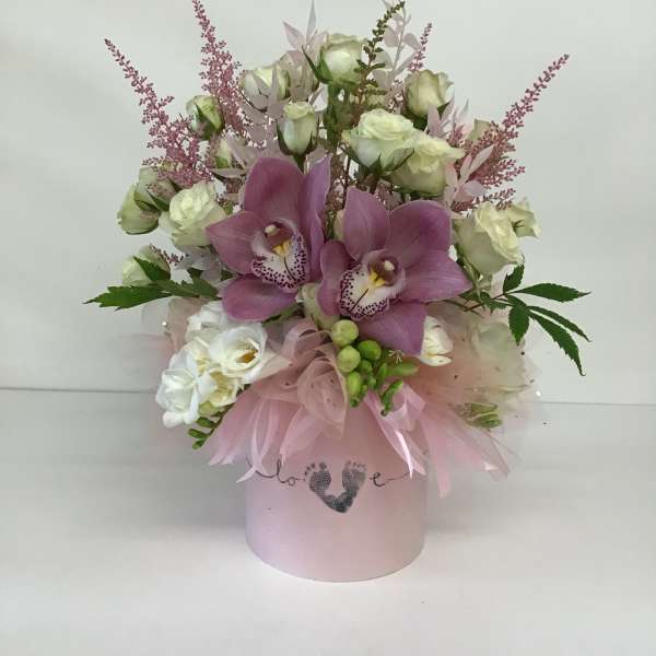 Pink orchid and white rose arrangement in a pastel hatbox