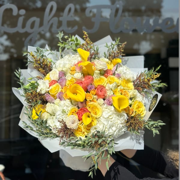 Large bouquet of yellow calla lilies, roses, and white hydrangeas