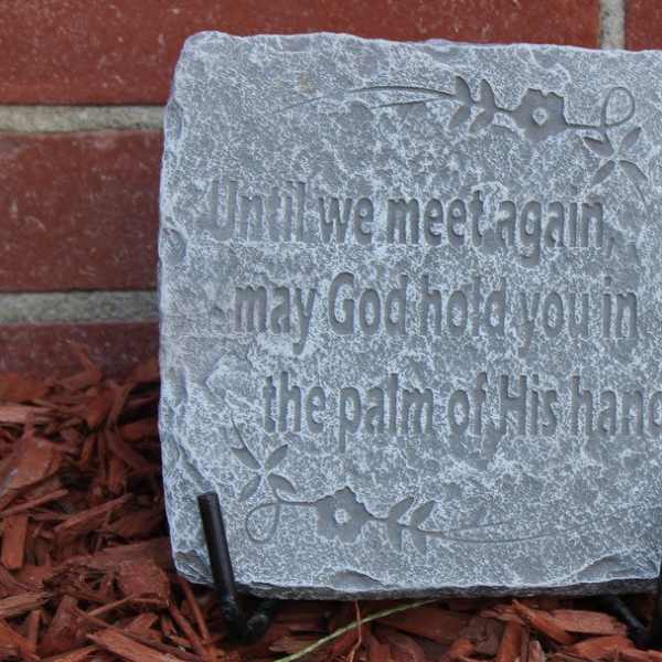 Engraved stone plaque with a quote on a stand