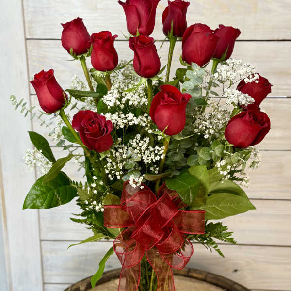 Bouquet of red roses with baby's breath in a glass vase