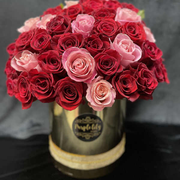 Bouquet of red and pink roses in a gold hat box