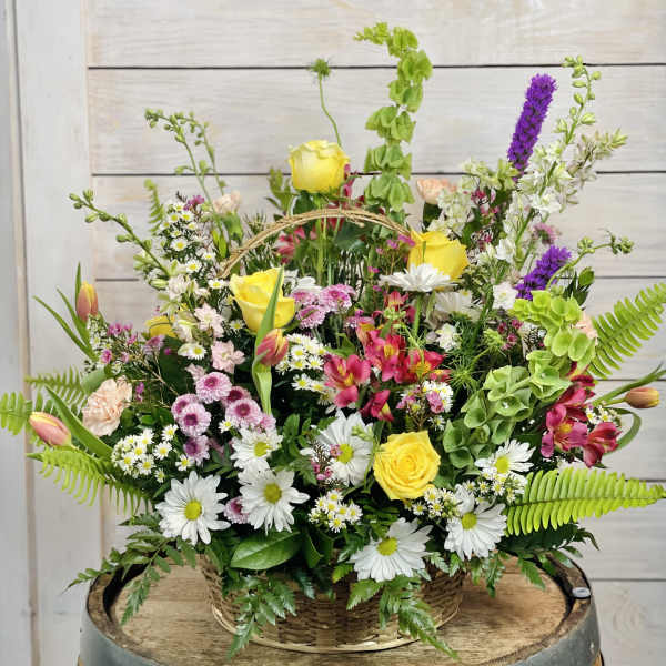 Mixed flower basket with yellow roses, daisies, and pink blooms