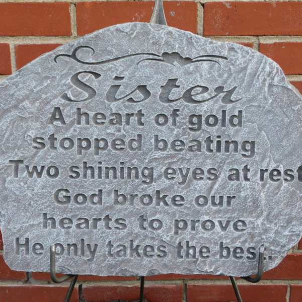 Memorial stone plaque with engraved text on a brick wall