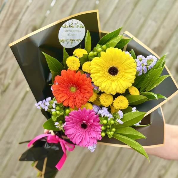 Bouquet of colorful gerbera daisies wrapped in black paper