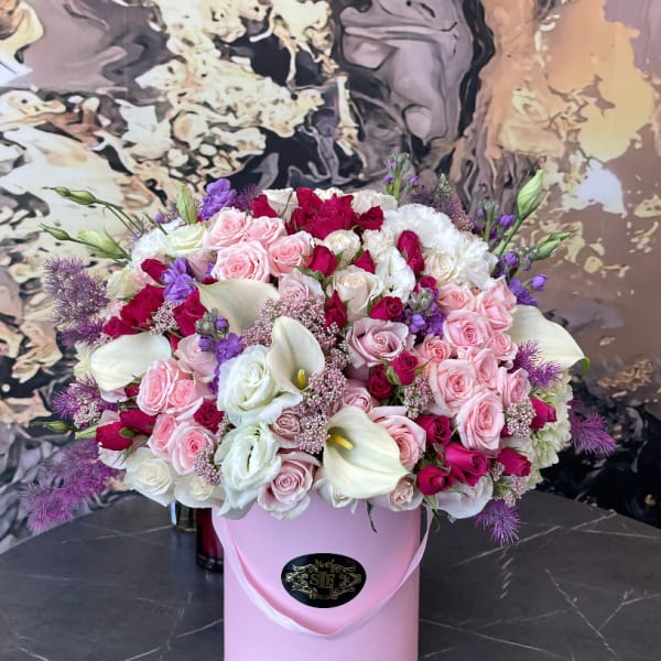 Pink and white rose bouquet with calla lilies in a pink hatbox