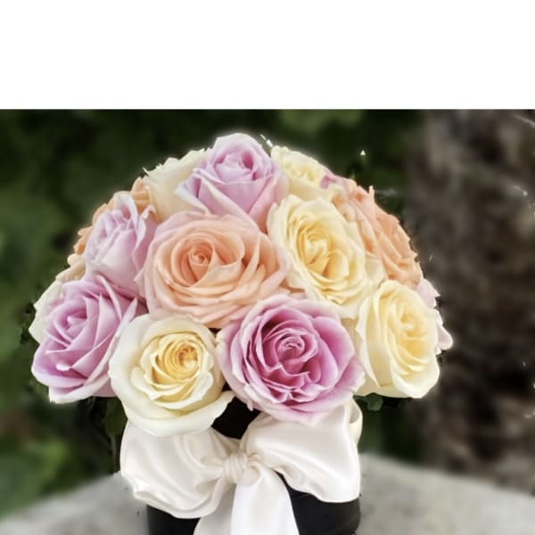 Pastel rose bouquet with a white ribbon on a black box