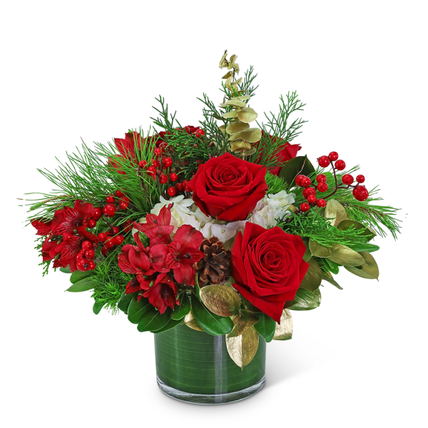 Red roses and red flowers in a glass vase with pine and berries