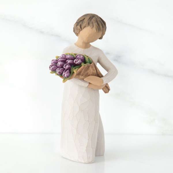 Figurine of a girl holding a bouquet of purple tulips