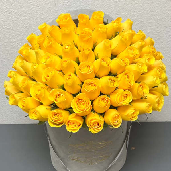 Bouquet of yellow roses in a gray hatbox