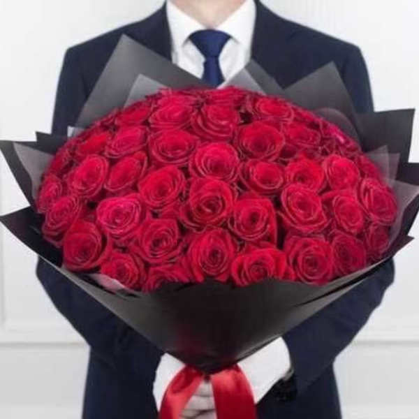 Large bouquet of red roses wrapped in black paper with a red ribbon