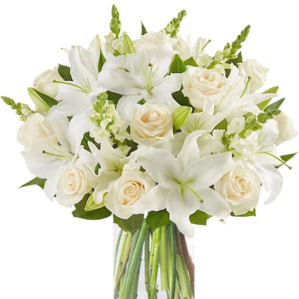 White lilies and cream roses in a clear glass vase
