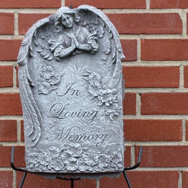 Gray memorial plaque with angel relief and the words In Loving Memory