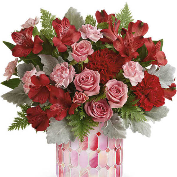 Pink and red flower arrangement in a patterned vase
