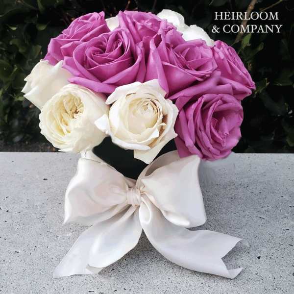 Bouquet of lavender and white roses tied with a white ribbon