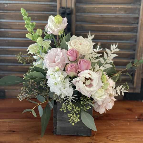 Pink and white floral arrangement in a black wooden box