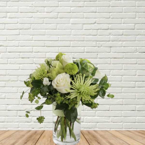 Green and white bouquet in a clear glass vase