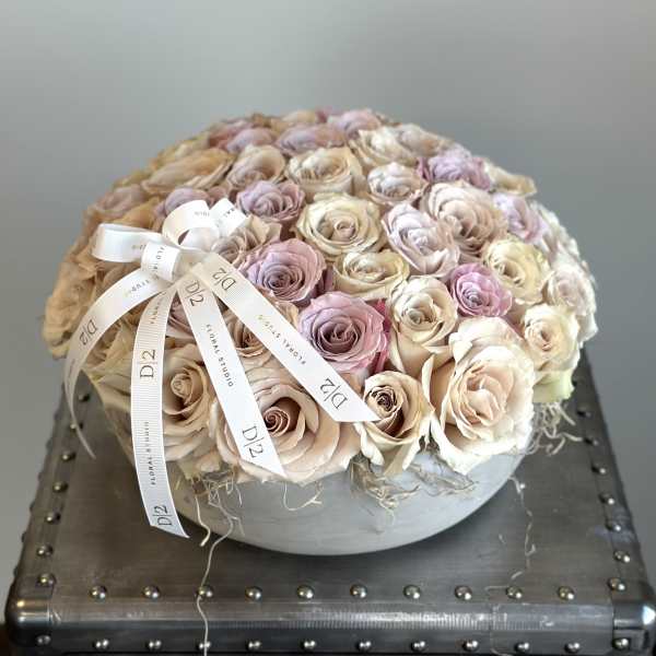 Round bouquet of blush and cream roses with a ribbon bow