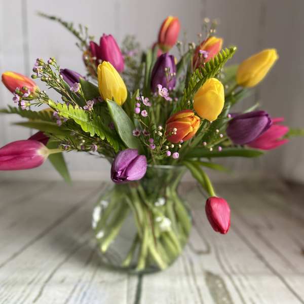 Colorful tulips arranged in a clear glass vase