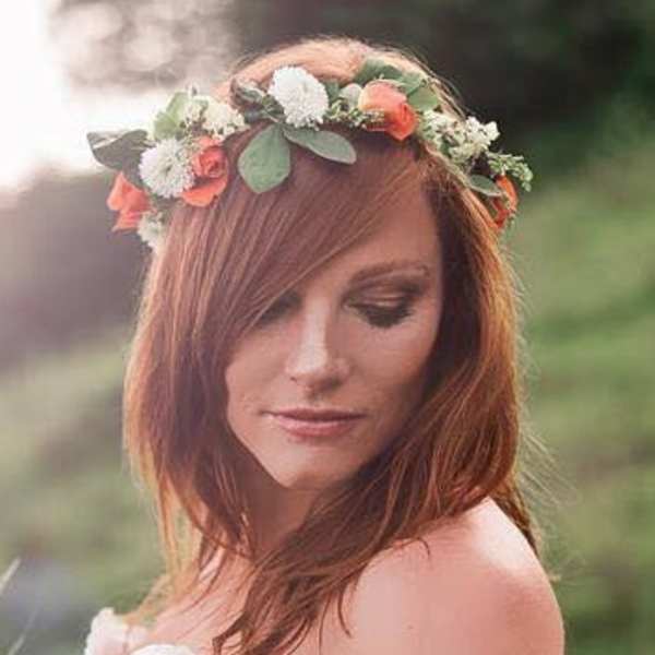 Woman wearing a floral crown with white and coral flowers
