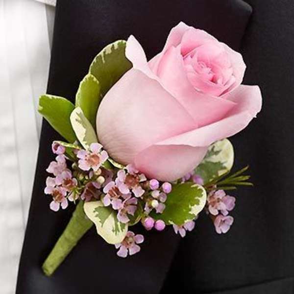 Pink rose boutonniere with small purple flowers and green leaves