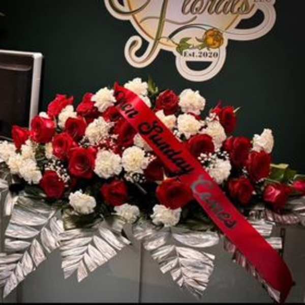 Red roses and white carnations arranged on a silver casket