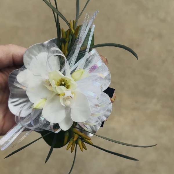 White orchid corsage with sheer ribbon and long grass-like accents