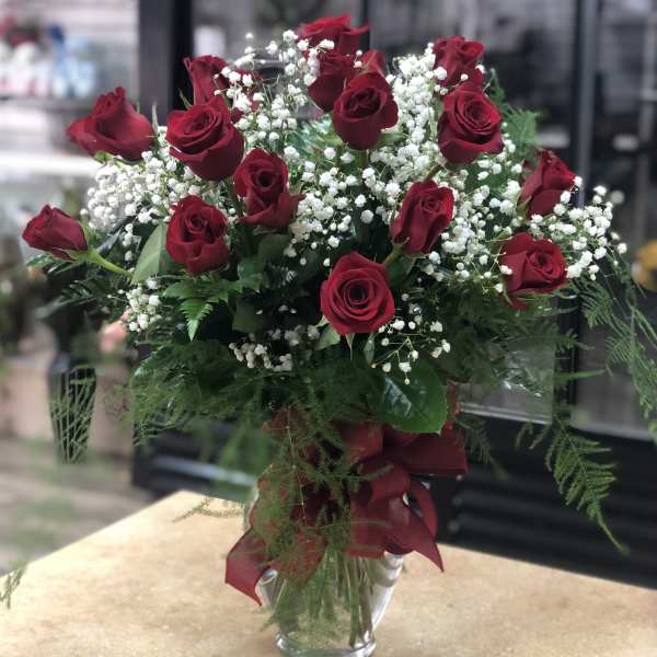 Red roses and white baby's breath in a clear glass vase