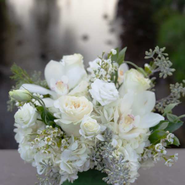 White floral arrangement in a clear square vase