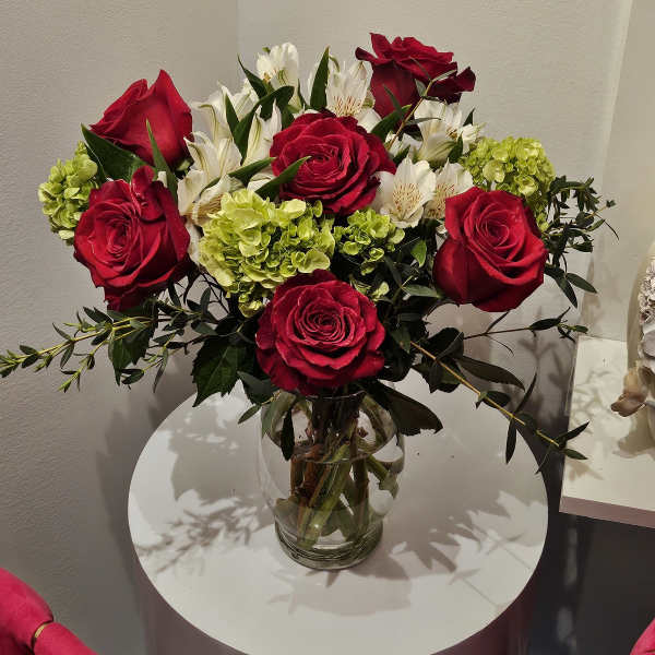 Red roses and white alstroemeria in a clear glass vase