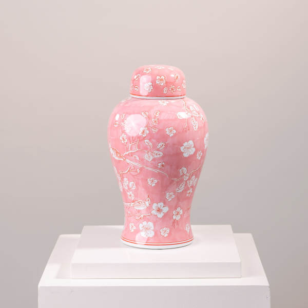 Pink ceramic jar with white floral cherry blossom pattern on a pedestal