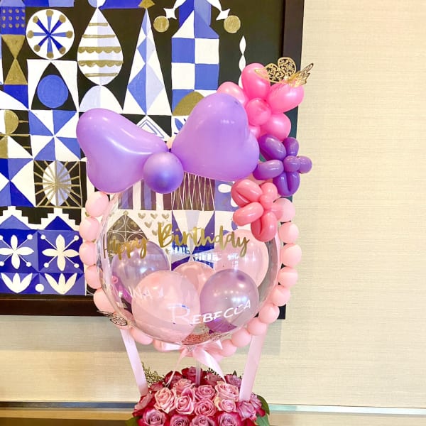 Birthday balloon display with pink roses in a gift box