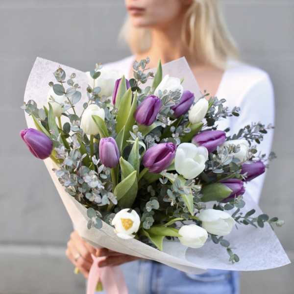 Bouquet of purple and white tulips with eucalyptus in paper wrap