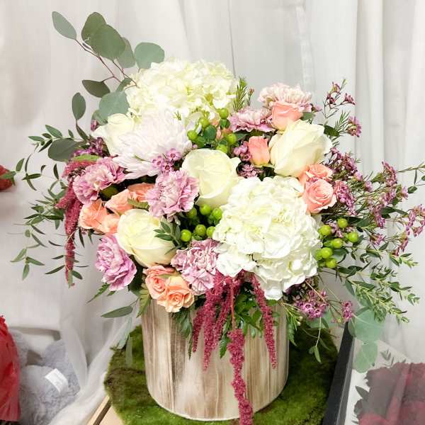 Bouquet of white and blush flowers in a wooden container