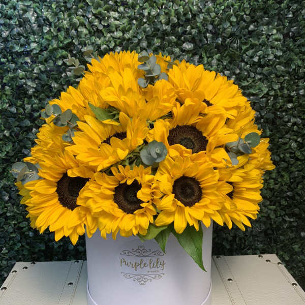 Yellow sunflowers arranged in a white hat box