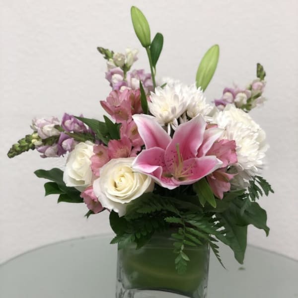 Pink lilies and white roses in a clear glass vase