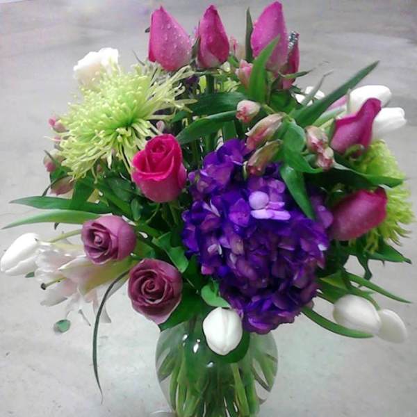 Bouquet of pink, purple, and white flowers in a glass vase
