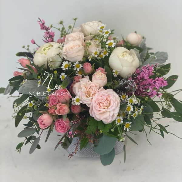 Pink and white rose bouquet with daisies in a low container