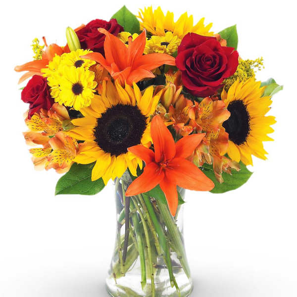 Bouquet of sunflowers, red roses, and orange lilies in a glass vase