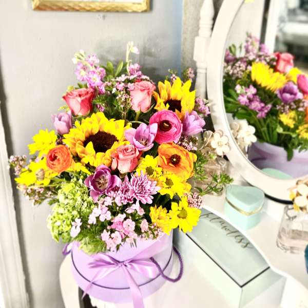 Colorful mixed bouquet in a lavender hat box with a ribbon