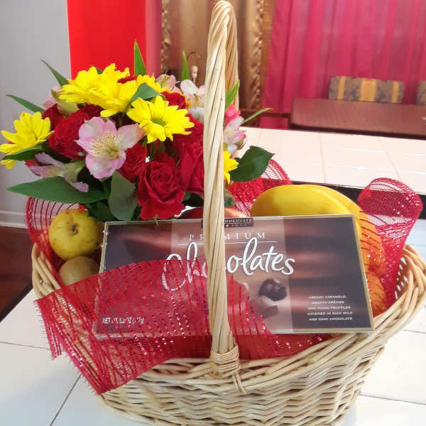 Basket of mixed flowers with chocolates and fruit