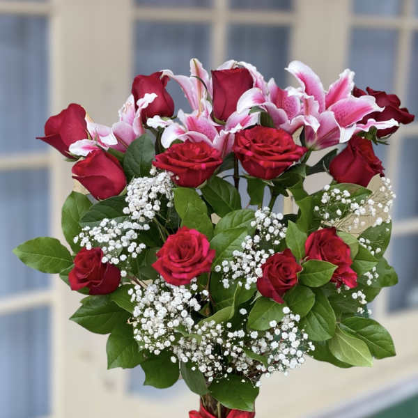Bouquet of red roses and pink lilies in a glass vase