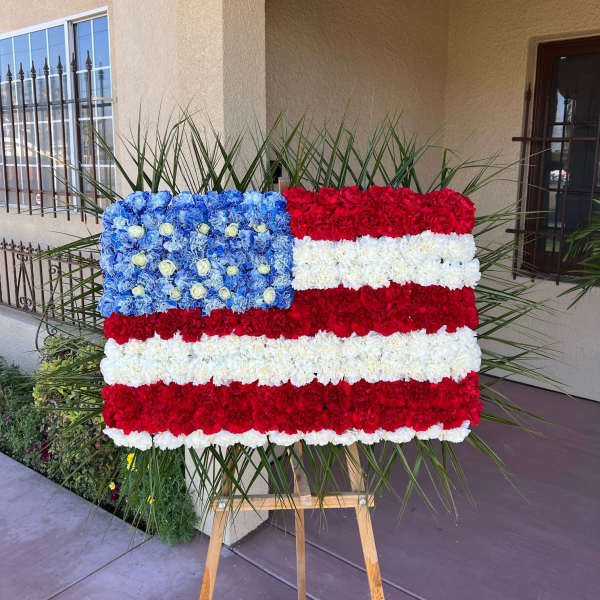 Floral arrangement shaped like the U.S. flag on an easel
