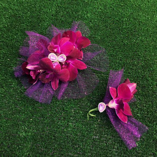 Two purple orchid corsages with glittery tulle and jeweled centers